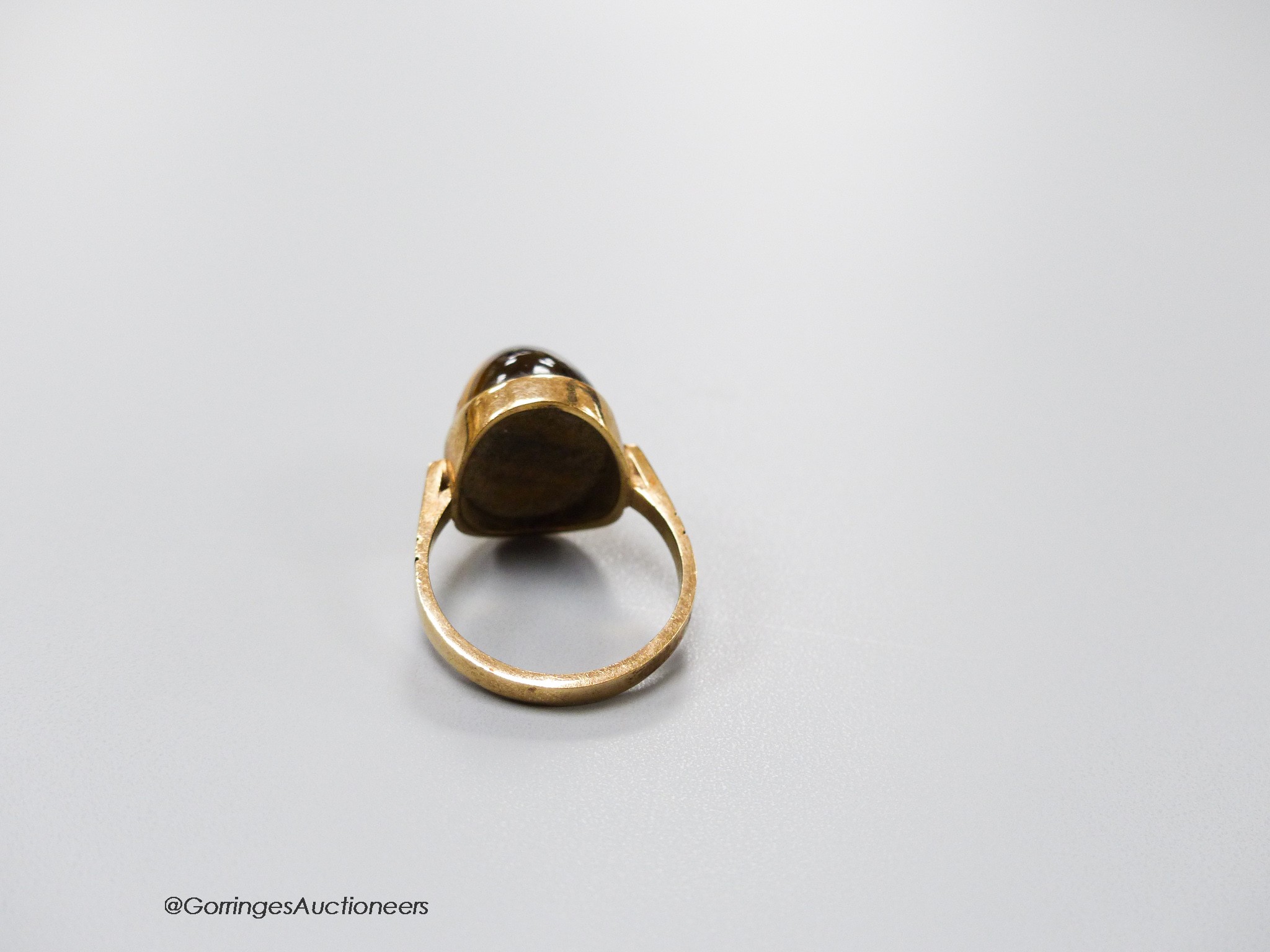 A 9ct and cabochon tiger's eye quartz set dress ring, size O, gross 5.4 grams.